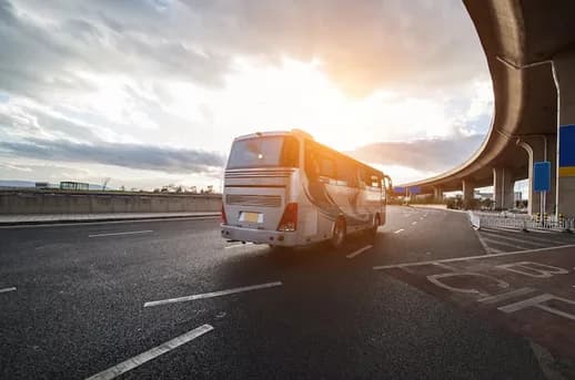 An OCI bus on the highway at sunset between southern Namibian towns